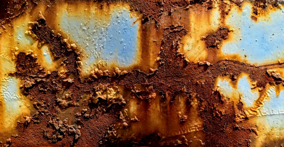 close up of brown and orange rust with peeling paint